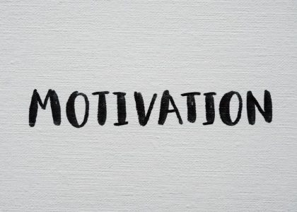 Inspirational word 'Motivation' in black on a white textured canvas background.